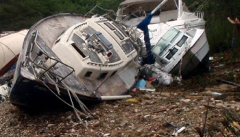 An overturned boat rests on the riverbank