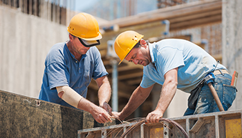 Two men actively working together on a construction site